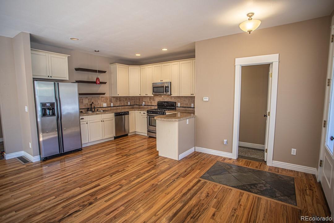 710 East Baseline Road Lafayette, CO 80026 - Photo 6 of 33 a kitchen with granite countertop a refrigerator and a stove top oven