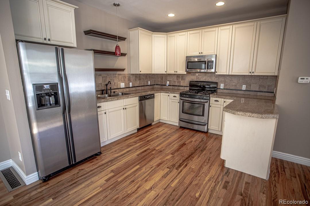 710 East Baseline Road Lafayette, CO 80026 - Photo 8 of 33 a kitchen with stainless steel appliances granite countertop a refrigerator a sink dishwasher a stove and white countertops with wooden floor