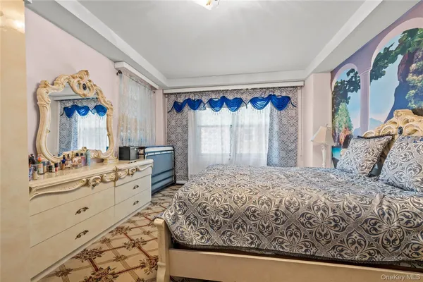 a bedroom with a bed and a mirror on the dresser