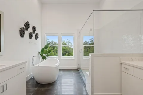 a white bath tub sitting in a bathroom next to a window