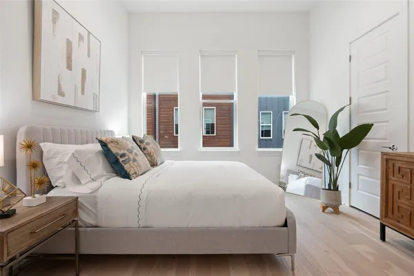 a bedroom with a large bed and potted plant