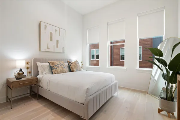a bedroom with a bed lamp and a potted plant
