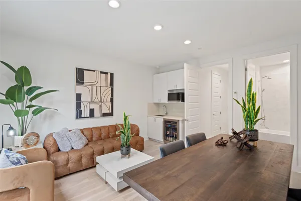 a living room with furniture a fireplace a potted plant and a window
