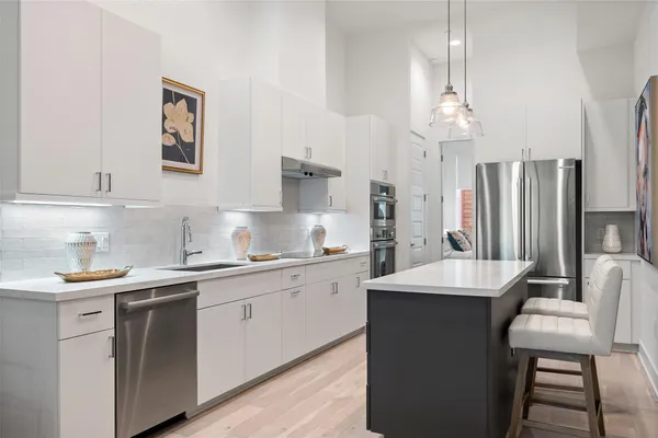 a kitchen with stainless steel appliances a sink stove and refrigerator