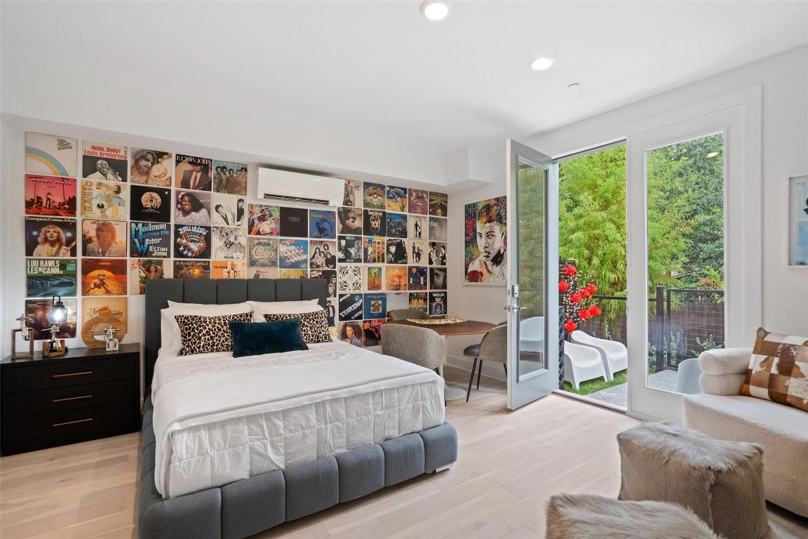 2505 Bluebonnet Lane, Unit 13 Austin, TX 78704 - Photo 22 of 29 Bedroom featuring wood finished floors, access to exterior, a wall mounted AC, and recessed lighting