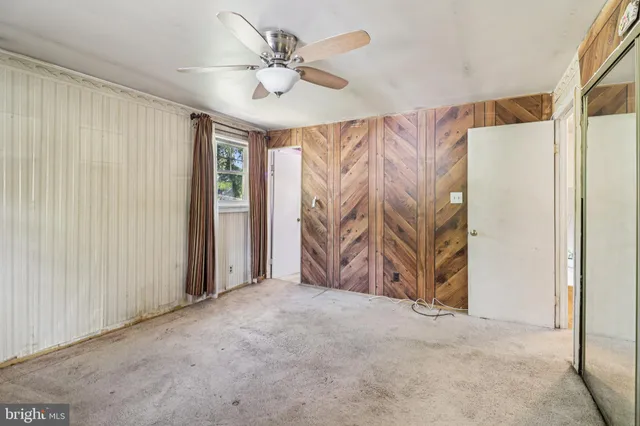 a view of a room with a ceiling fan and closet