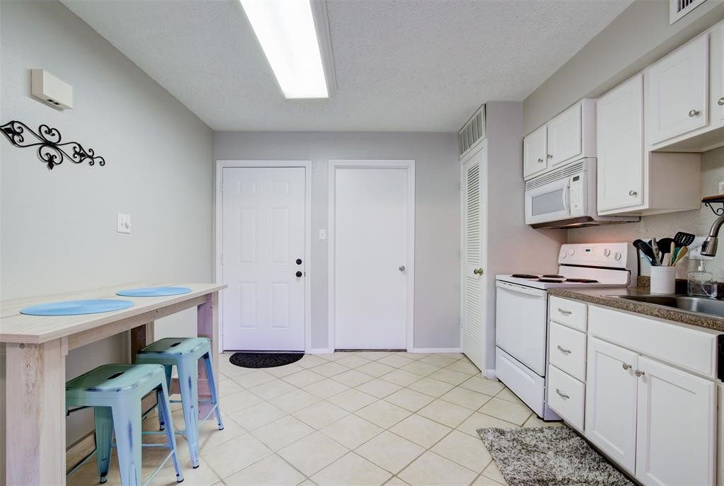 12900 Walden Road, Unit 202B Montgomery, TX 77356 - Photo 11 of 30 a kitchen with stainless steel appliances kitchen island granite countertop a refrigerator and a stove top oven