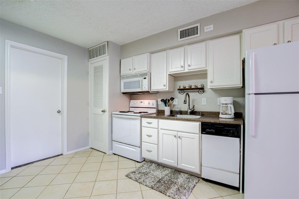 12900 Walden Road, Unit 202B Montgomery, TX 77356 - Photo 12 of 30 a kitchen with white cabinets and white appliances