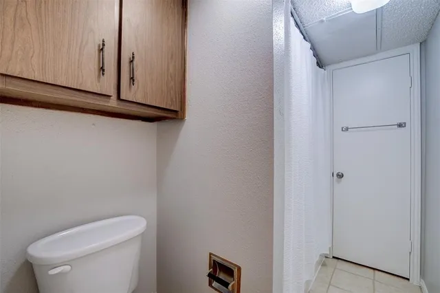 a white toilet sitting next to a shower curtain