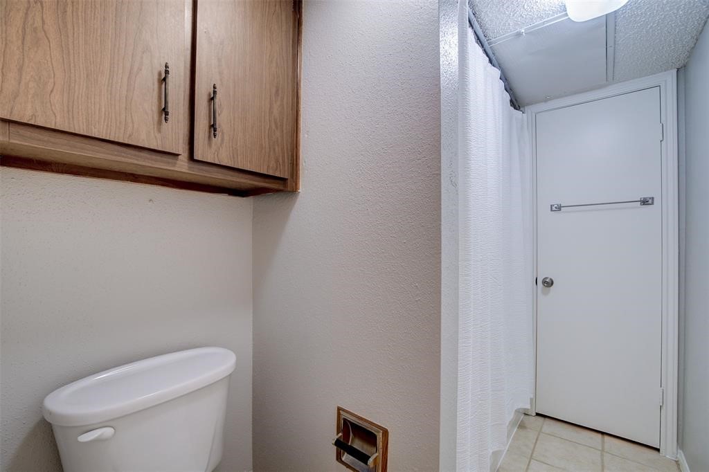 12900 Walden Road, Unit 202B Montgomery, TX 77356 - Photo 19 of 30 a white toilet sitting next to a shower curtain
