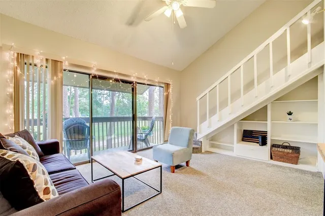 a living room with furniture a fireplace and a large window