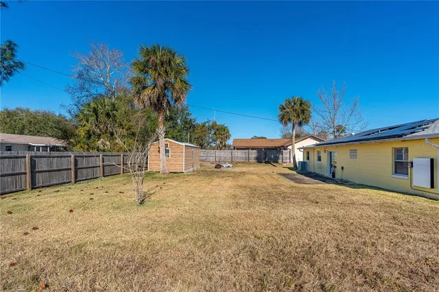 a view of a house with backyard and sitting area
