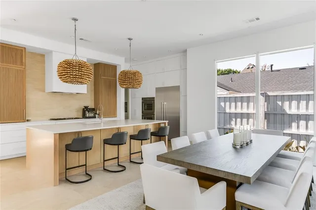 a room with a table chairs and flat screen