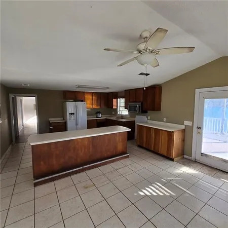 a large kitchen with a stove a sink dishwasher and a refrigerator