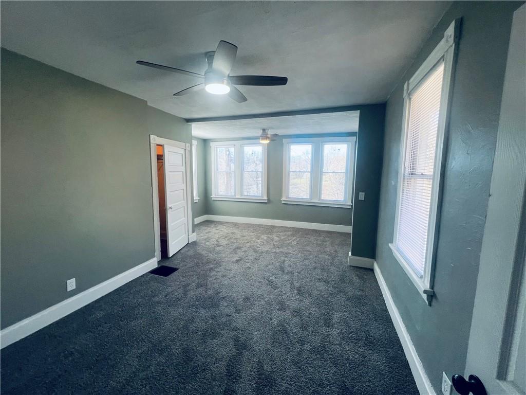 262 Adams Street Pittsburgh, PA 15221 - Photo 12 of 26 en empty room with windows and chandelier fan
