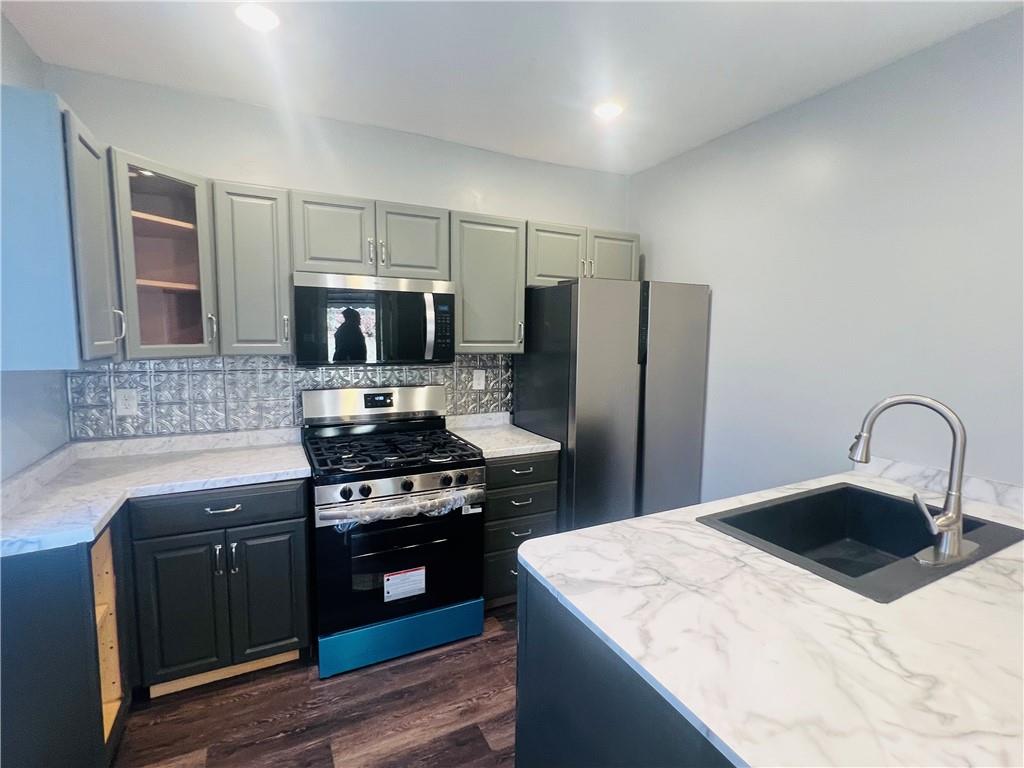262 Adams Street Pittsburgh, PA 15221 - Photo 7 of 26 a kitchen with a stove a refrigerator and a sink
