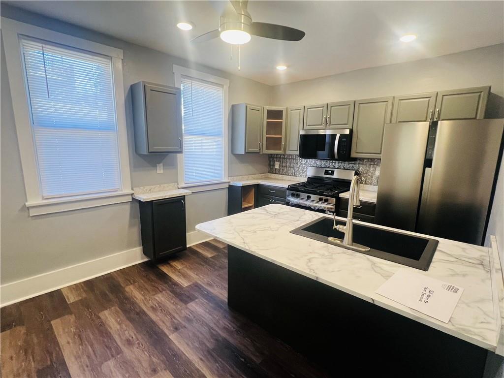 262 Adams Street Pittsburgh, PA 15221 - Photo 8 of 26 a kitchen with kitchen island white cabinets sink and stainless steel appliances