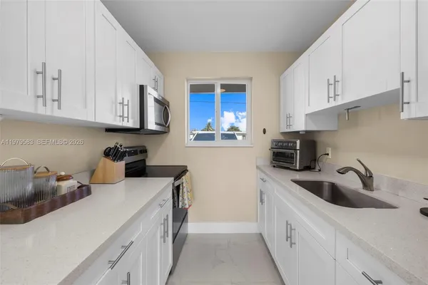 a kitchen with stainless steel appliances granite countertop a sink stove and cabinets