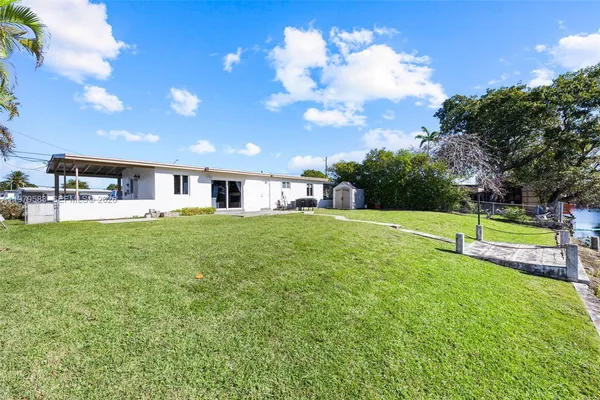 a view of a house with a backyard and a tree