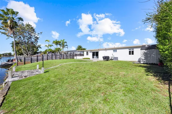 a view of a house with a big yard and a large tree