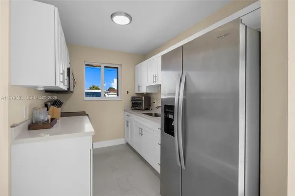 a kitchen with a refrigerator sink and cabinets