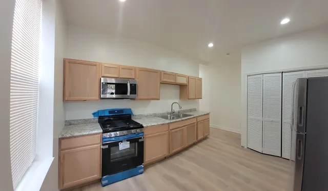 a kitchen with stainless steel appliances granite countertop a stove a sink and a refrigerator