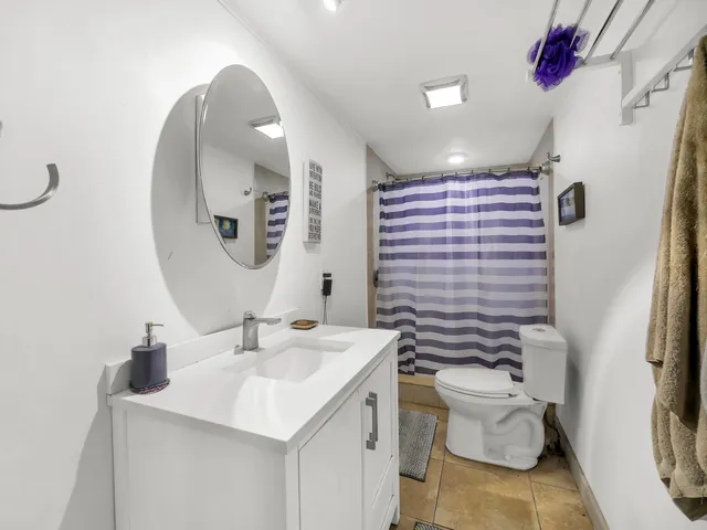 a bathroom with a sink vanity mirror and toilet