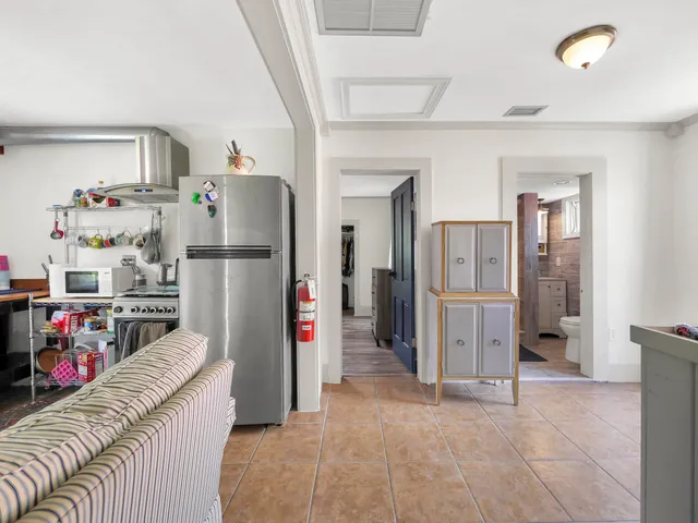 a living room with furniture and a refrigerator