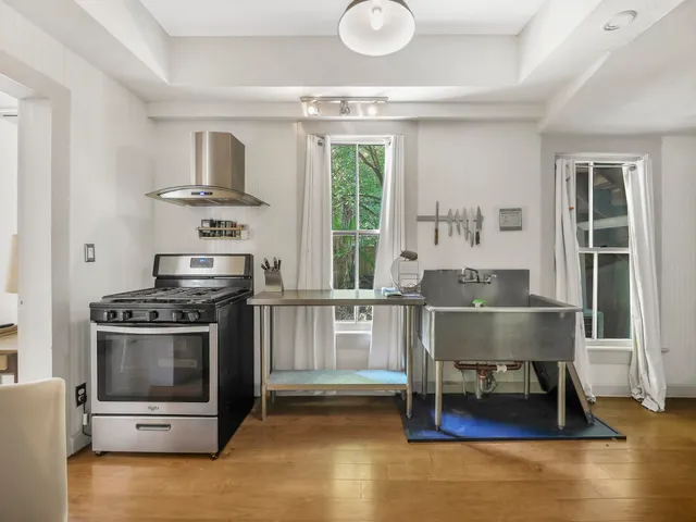 a kitchen with a stove a refrigerator and a dining table