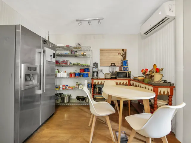 a utility room with stainless steel appliances a table and chairs
