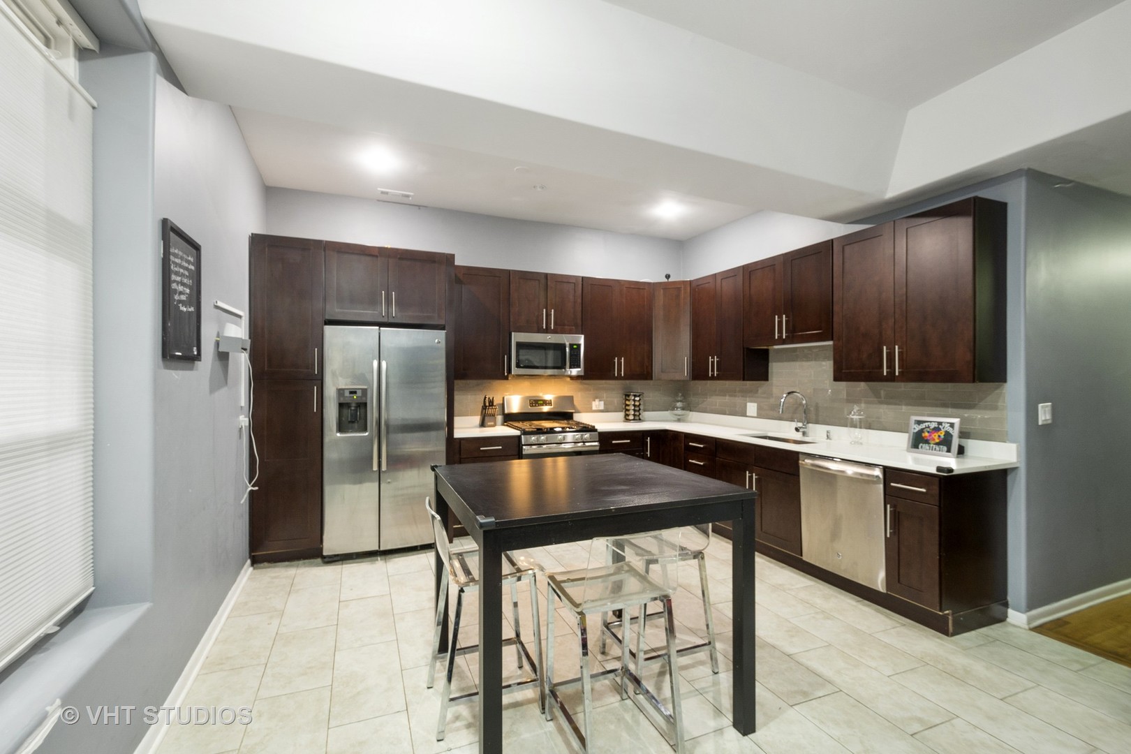 4530 South Prairie Avenue, Unit 1N Chicago, IL 60653 - Photo 3 of 11 a kitchen with stainless steel appliances kitchen island granite countertop a refrigerator and a sink