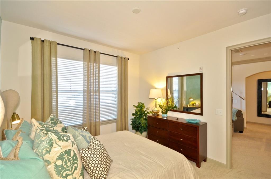 3695 Cumberland Boulevard Southeast, Unit 1129 Atlanta, GA 30339 - Photo 11 of 34 a bedroom with a bed and a large mirror next to a window