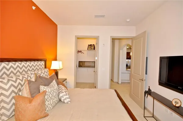 a bedroom with a bed and a flat screen tv