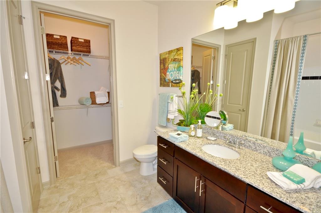 3695 Cumberland Boulevard Southeast, Unit 1129 Atlanta, GA 30339 - Photo 15 of 34 a bathroom with a granite countertop sink and a mirror
