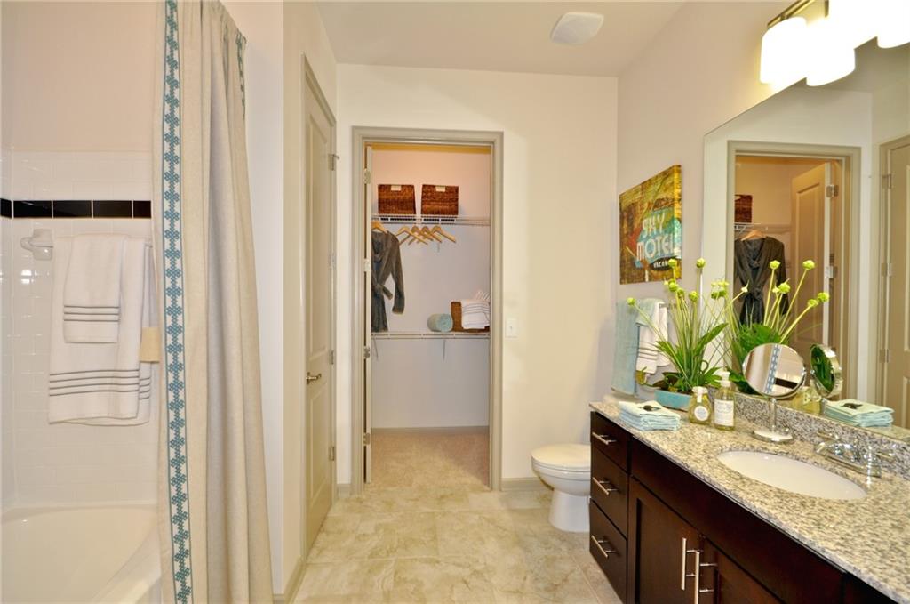 3695 Cumberland Boulevard Southeast, Unit 1129 Atlanta, GA 30339 - Photo 16 of 34 a bathroom with a granite countertop sink and a mirror