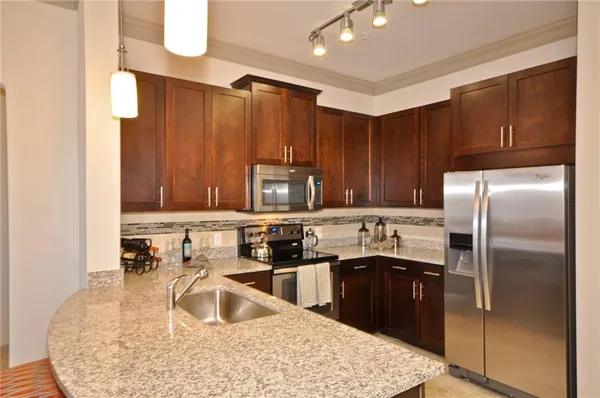 a kitchen with kitchen island a sink stainless steel appliances and cabinets