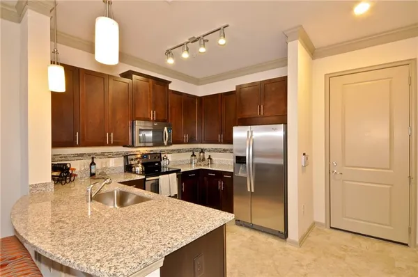 a kitchen with stainless steel appliances granite countertop a sink refrigerator and microwave