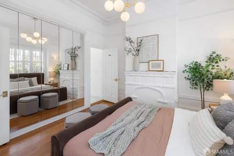 a bedroom with a large bed couch and a potted plant