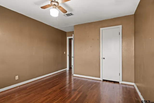 a view of an empty room with wooden floor