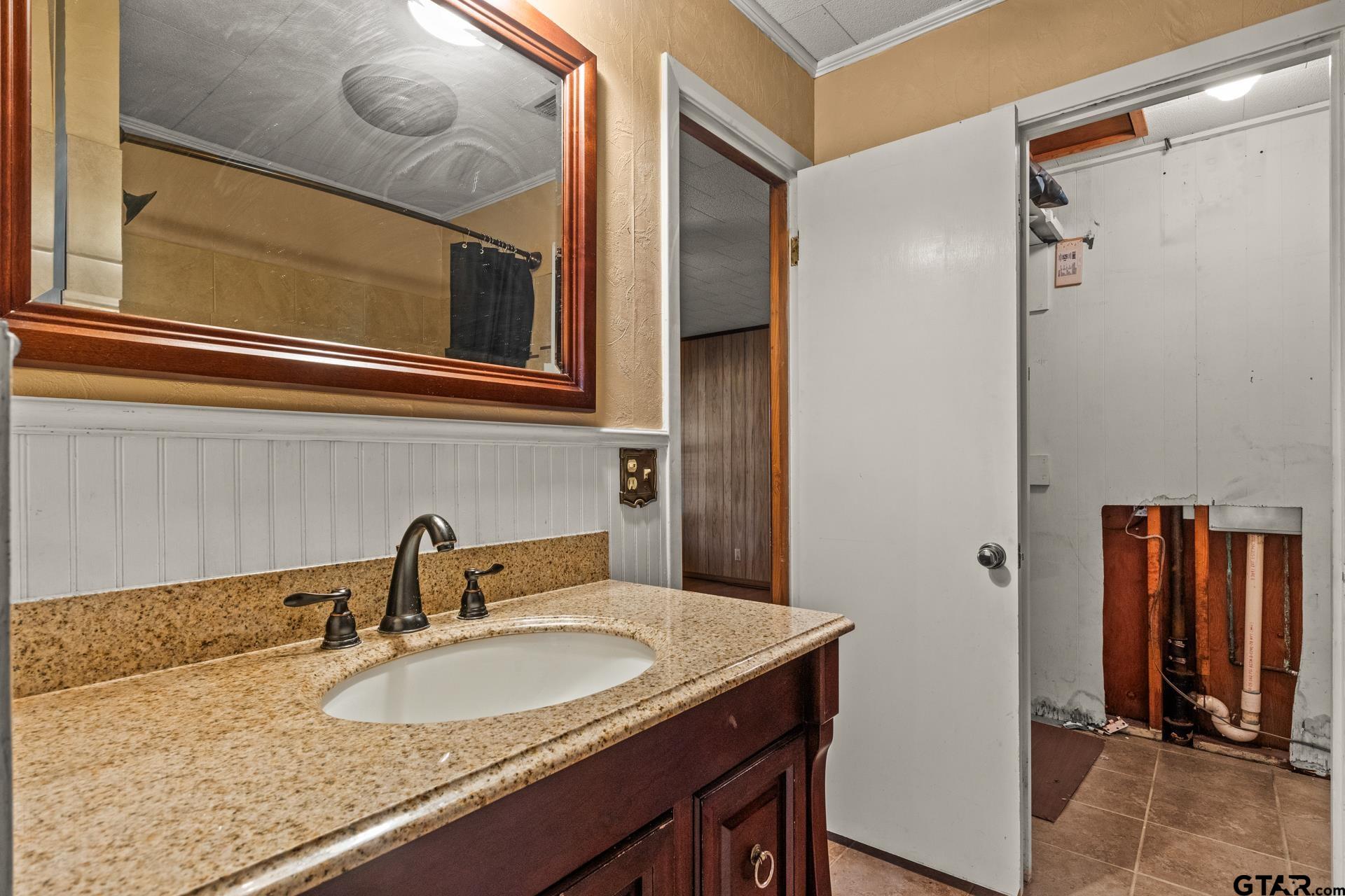 302 Smith Street Naples, TX 75568 - Photo 18 of 28 a bathroom with a granite countertop sink and a mirror