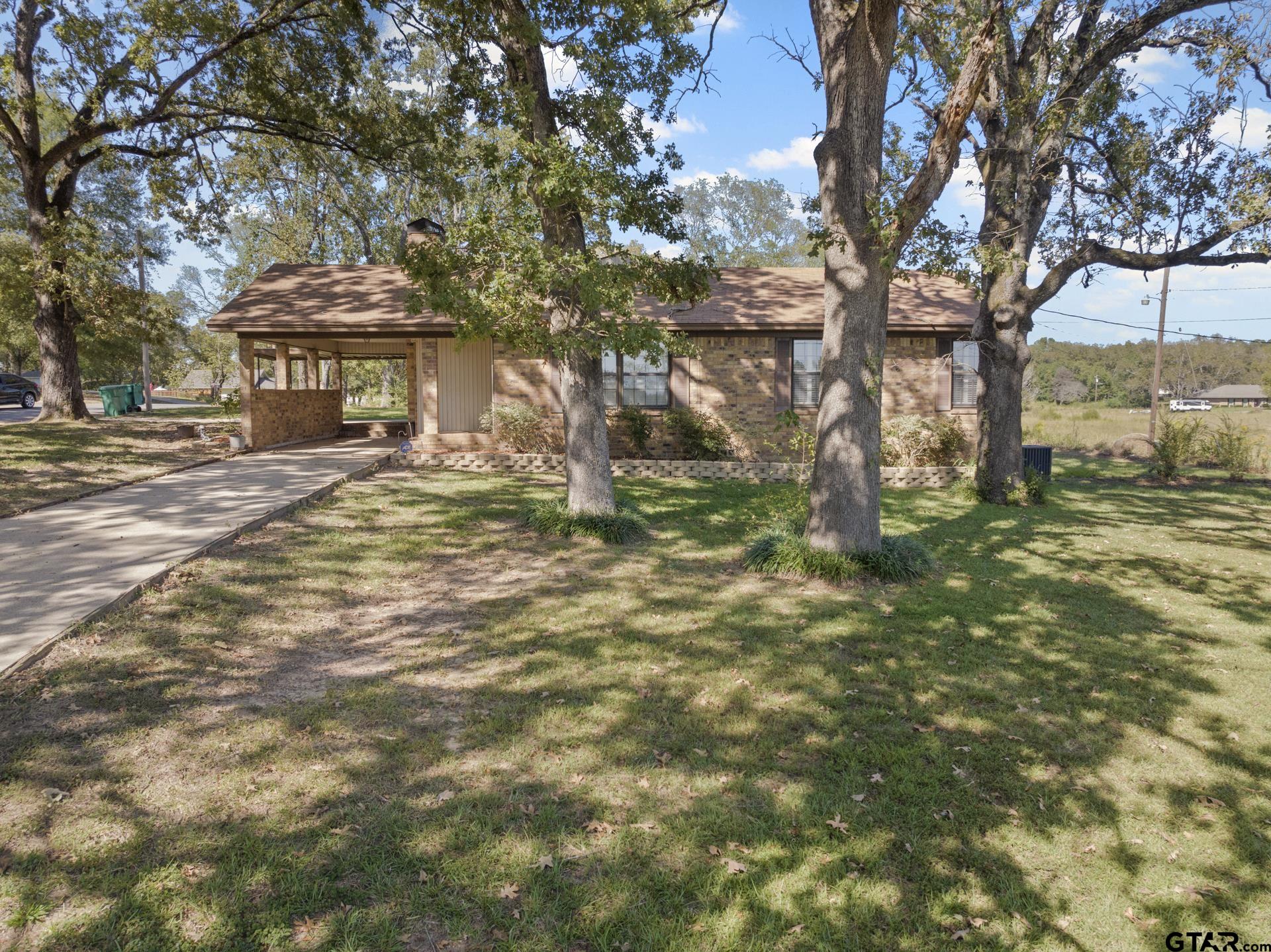 302 Smith Street Naples, TX 75568 - Photo 2 of 28 a view of a house with a tree in the yard