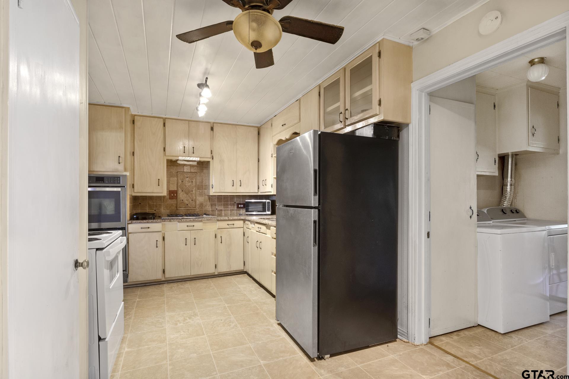 302 Smith Street Naples, TX 75568 - Photo 5 of 28 a kitchen with stainless steel appliances a refrigerator and a stove top oven