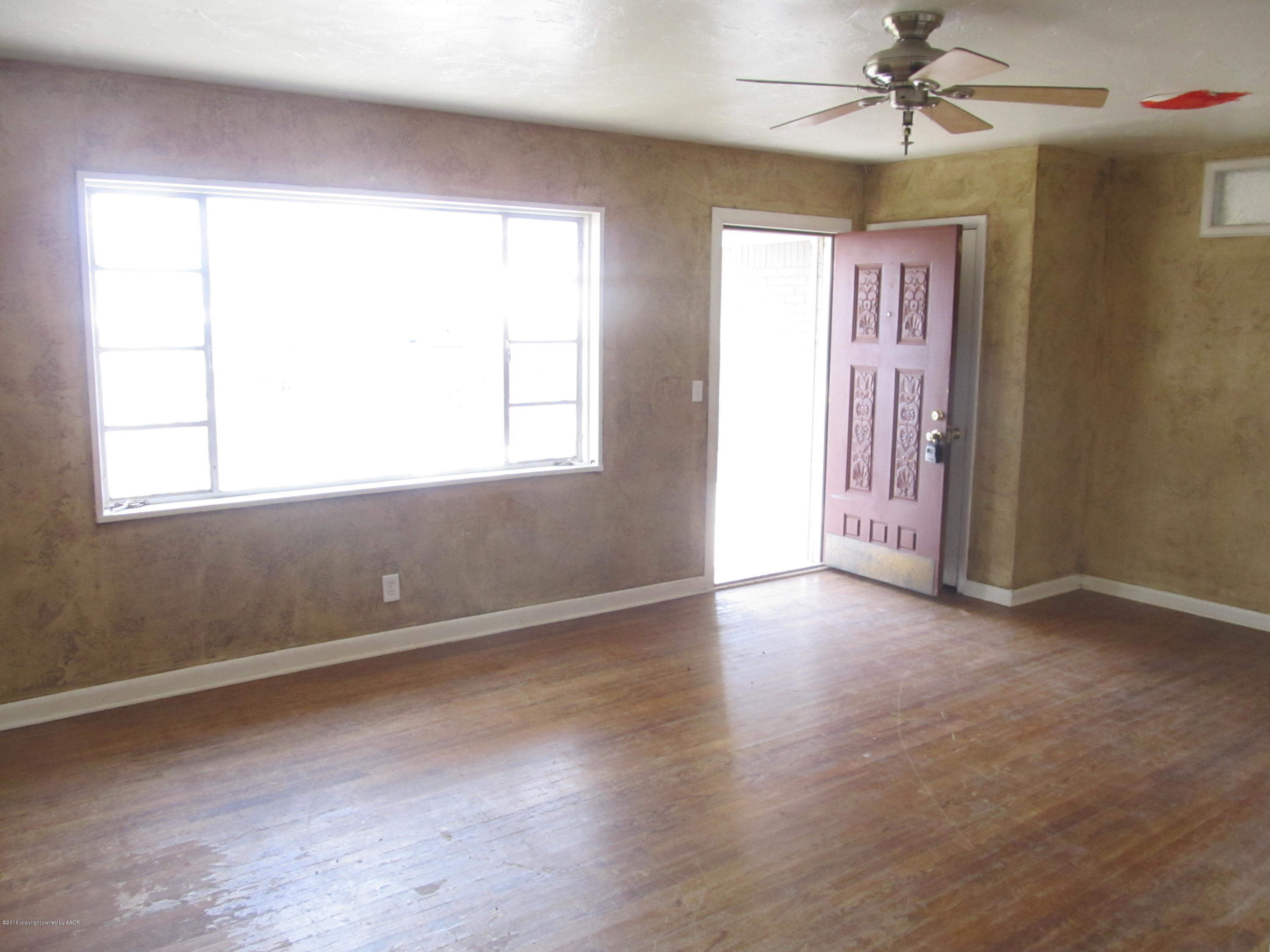 4103 South Bonham Street Amarillo, TX 79110 - Photo 2 of 13 an empty room with wooden floor fan and windows