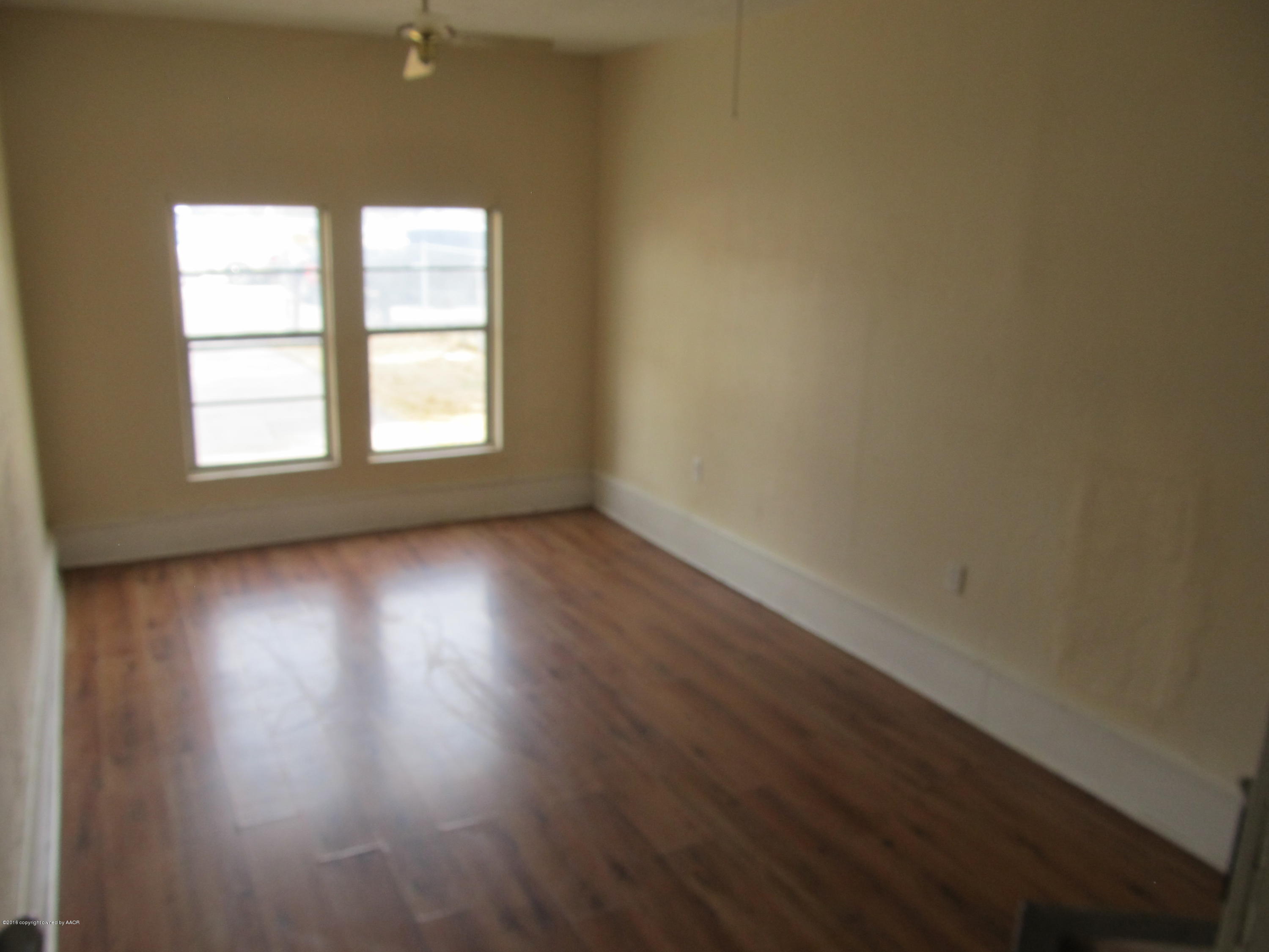 4103 South Bonham Street Amarillo, TX 79110 - Photo 4 of 13 an empty room with wooden floor and windows