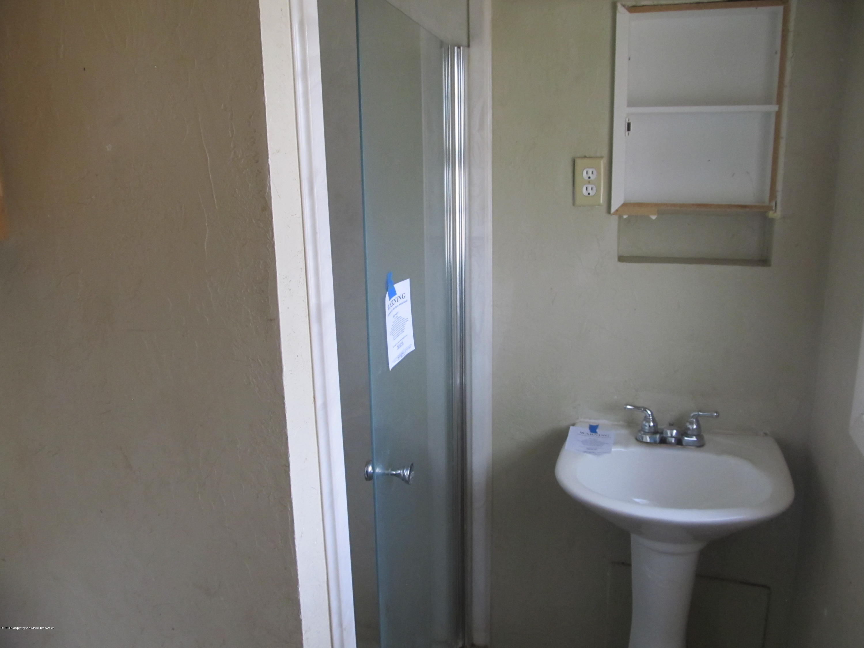 4103 South Bonham Street Amarillo, TX 79110 - Photo 10 of 13 a bathroom with a sink and a mirror