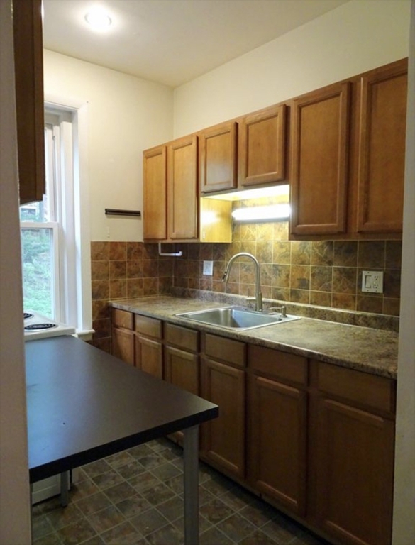 15 University, Unit 22 Brookline, MA 02445 - Photo 3 of 10 a kitchen with stainless steel appliances granite countertop a sink a stove a counter space and cabinets