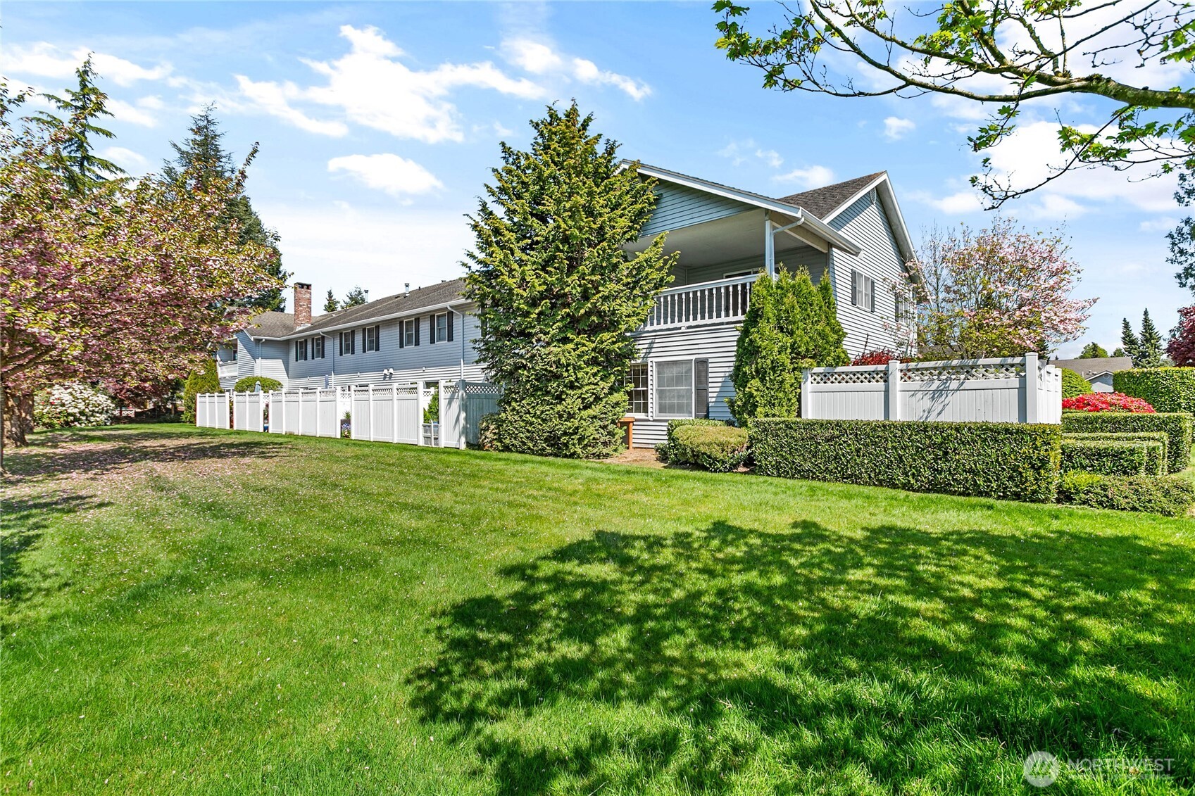 1843 Main Street, Unit A1 Lynden, WA 98264 - Photo 37 of 37 a view of a white house next to a yard with big trees