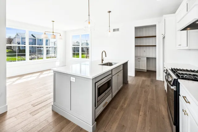 a kitchen with stainless steel appliances kitchen island granite countertop a sink a counter space and cabinets
