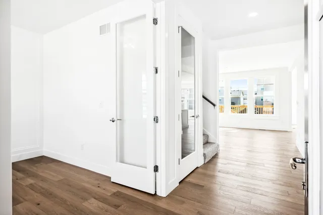 a view of a hallway with wooden floor and staircase