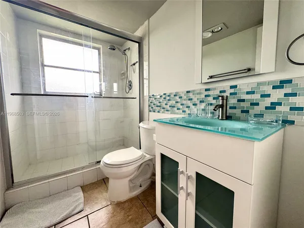 a bathroom with a sink toilet and shower